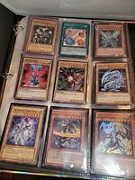 Binder page with nine Yu-Gi-Oh cards including Blue-Eyes White Dragon and Red-Eyes Black Dragon