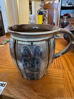 Pitcher side view showing blue floral glaze and handle