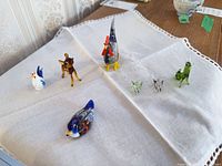 Group shot of all seven glass figurines on cloth