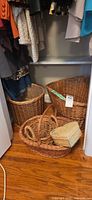 All four wicker items grouped: large oval hamper, medium round basket, shallow tray basket, small lidded box