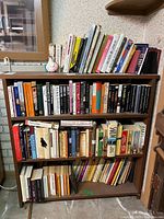 Full bookshelf with three shelves of assorted books