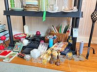 Overall view showing various candles, holders and matches on shelf and floor