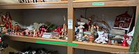 wide view of two shelves full of assorted Christmas decorations including figurines, ornaments, garland, ceramic pieces