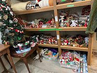 Shelving unit showing 43 in decorated tree, bins and shelves filled with various ornaments, figurines, ribbons, wrapping paper