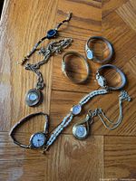 All eight ladies watches laid out on wooden surface
