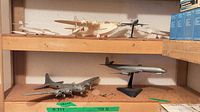 Two shelf view showing multiple assembled model airplanes
