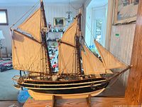 Full view of ship model on stand showing sails, masts and hull