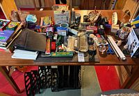 Overall view of desk with calculators, staplers, pencils, binder, file sorter and assorted supplies