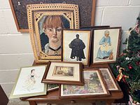 Group shot shows oil portrait in wicker frame, several framed prints and two additional frames