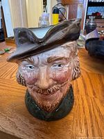 Front view of Robin Hood toby jug on wooden surface