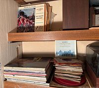 Shelf with stack of LPs and pile of 45s beside them
