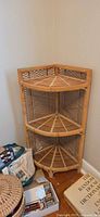 Full view of wicker corner shelf showing three tiers and lattice sides