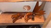 Shelf view showing all seven carved wood pieces