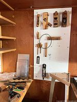 Overview of board with wooden planes, metal plane, chisels, marking gauge, and accessories