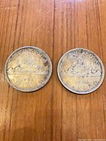 Two 1966 Canadian silver dollars reverse side with Voyageur design visible