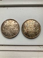 Front view of both 1966 Canada silver dollars, Voyageur design visible