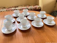 Overhead view of all 10 cup and saucer sets displayed on table