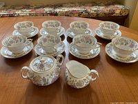 Full set showing eight cup and saucer pairs, creamer, sugar bowl with lid
