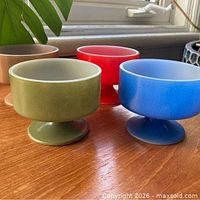 Four colored pedestal dessert bowls on table