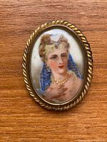 Front view of brooch showing painted portrait and frame