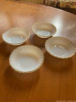 Four matching milk glass dessert bowls on tabletop