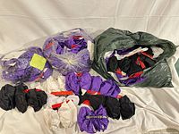 Bulk bags and loose groups of purple, black and white satin bow hair ties, Revlon cards visible