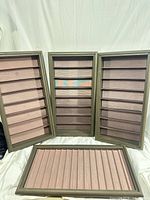 Four rectangular display cases, three standing vertical, one horizontal showing ridged interior