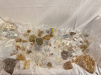 Overview of numerous plastic bags with assorted metal jewelry findings and beads