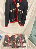 Cardigan on hanger showing front embroidery and trim