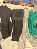 Group shot of all four vintage dresses hanging