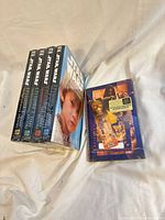 Front view of four sealed hardcover novels and sealed journal