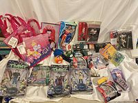 Group shot of entire lot showing all packaged figures, dolls, bags, train boxes, small toys