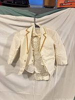 Full view of jacket, shirt, and pants on hanger