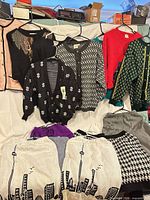 Group shot showing all sweaters and skirts laid out and hanging