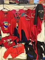 Group shot of all 10 garments laid out/hung, showing color range and graphics