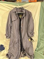 Front view of trench coat showing color, length, buttons, cuffs, tags