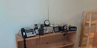 Full lot view on shelf showing phone, radios, clocks