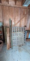 assorted wood boards, posts, and lattice leaning against wall