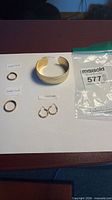 All jewelry pieces laid out: cuff bangle, two gold-filled rings, pair hoop earrings
