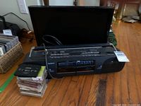 Sony boombox in front, LG monitor behind, stack of cassette tapes