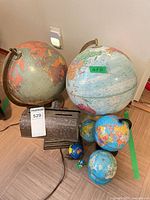 Group shot showing two large globes, three small globes and metal display light