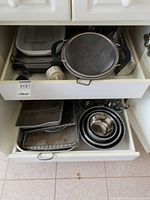 Drawer with mesh strainer, utensils, baking sheets, nested mixing bowls and bundt pan