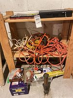 Wide view of shelving with tangled extension cords, boxed light bulbs and lighting parts