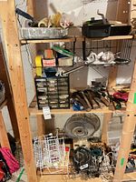 Wide view of shelving with paint supplies, parts organizer, hand tools, fan and wire racks