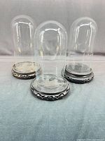 Three glass domes on carved stands