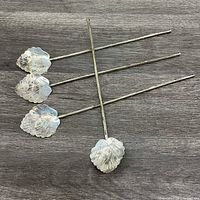 Four leaf-bowl sterling iced tea spoons angled on table