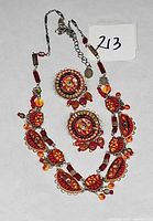 Necklace and both earrings laid flat showing full design