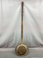 Full view of bed warmer showing entire length and handle