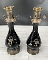 Front view of both black onyx glass lamps showing decoration and brass tops