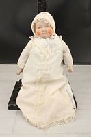 Full view of doll in gown and bonnet